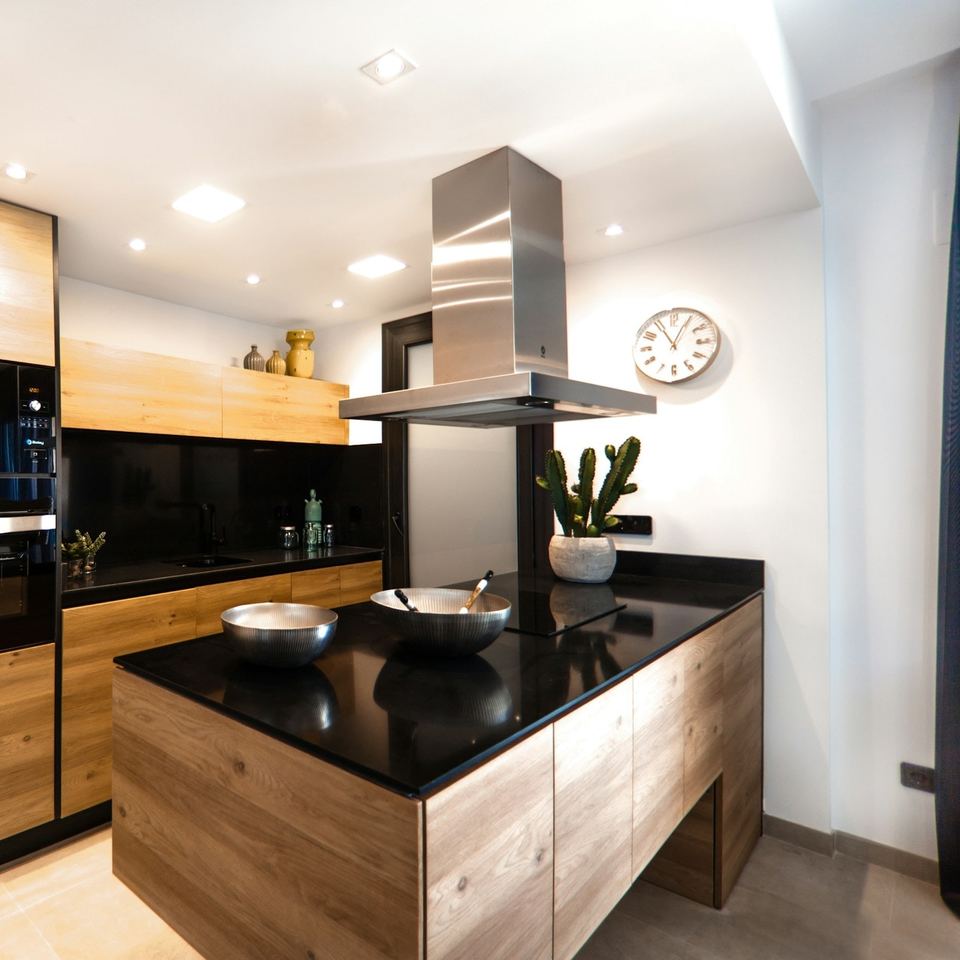 Kitchen with oak units and an island under a black worktop